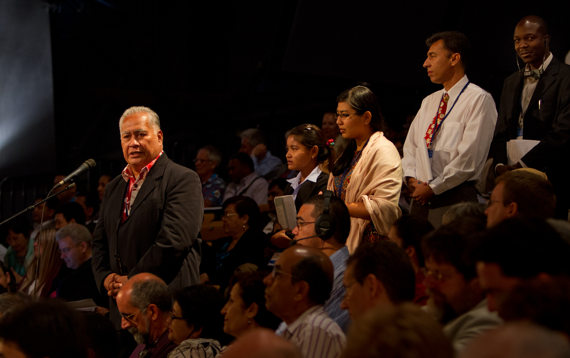 Delegates to the 11th International Baha'i Convention take their place in the queue to share their insights and experiences.