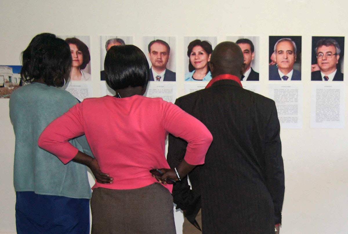 Participants in Uganda's Five Years Too Many conference viewing photographs of the seven imprisoned Iranian Baha'i leaders. The event, held on 15 May 2013 in Kampala, featured a call by the Inter-religious Council of Uganda for Iran to respect the rights of religious minorities.