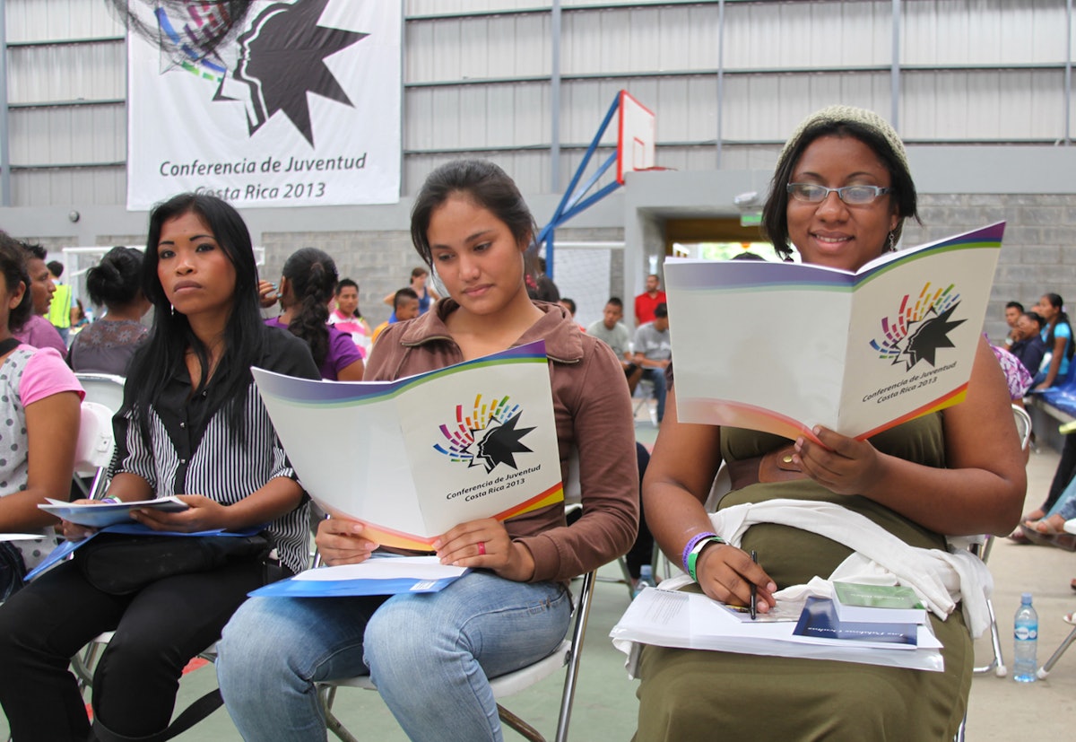 Youth study the conference agenda in San Jose, Costa Rica.