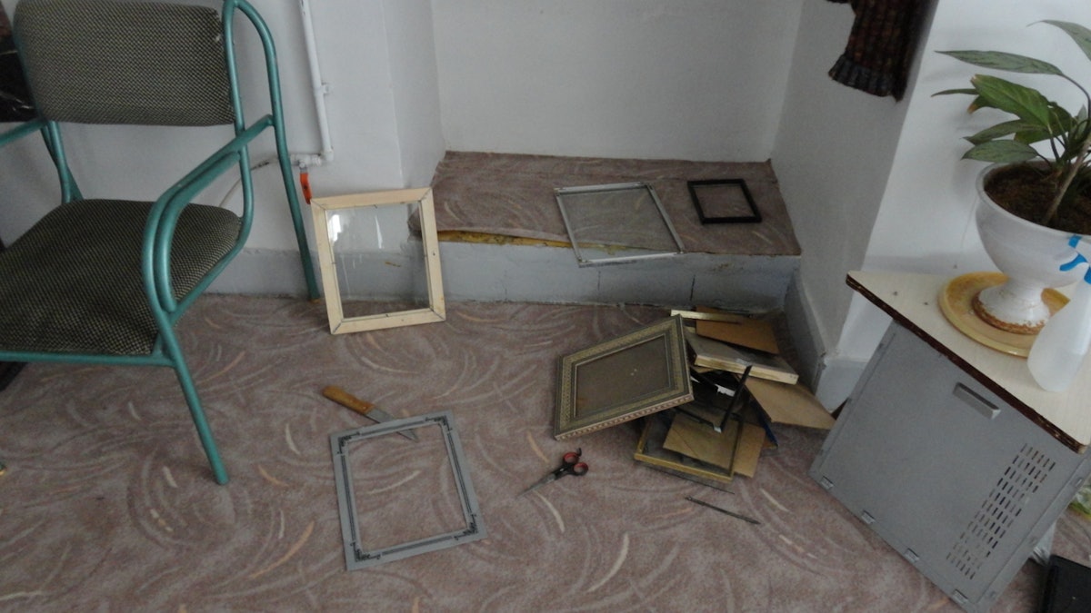 Iranian government agents confiscated photographs, Baha’i books, CDs, and computers during a raid on 14 homes in Abadeh, Iran, on 13 October 2013. Shown here are broken picture frames in a Baha’i home after the raid.