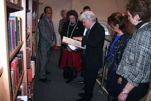 Dr. Moojan Momen shows a rare Persian-language manuscript to guests gathered at the official opening of the Afnan Library in Sandy, U.K., on 12 February 2015.