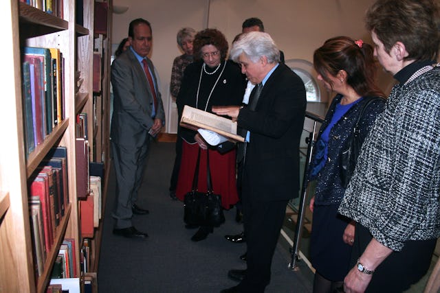 Dr. Moojan Momen shows a rare Persian-language manuscript to guests gathered at the official opening of the Afnan Library in Sandy, U.K., on 12 February 2015.