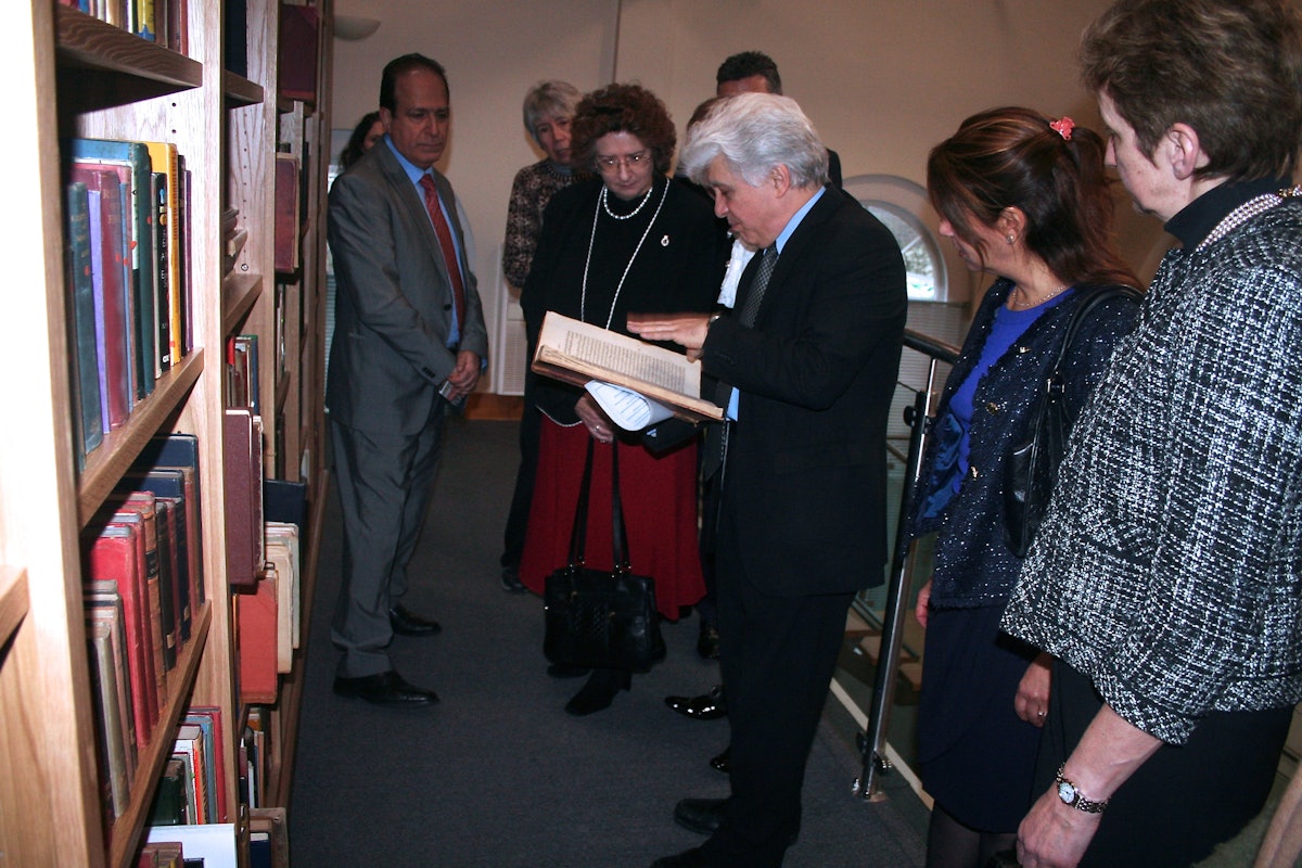 Dr. Moojan Momen shows a rare Persian-language manuscript to guests gathered at the official opening of the Afnan Library in Sandy, U.K., on 12 February 2015.