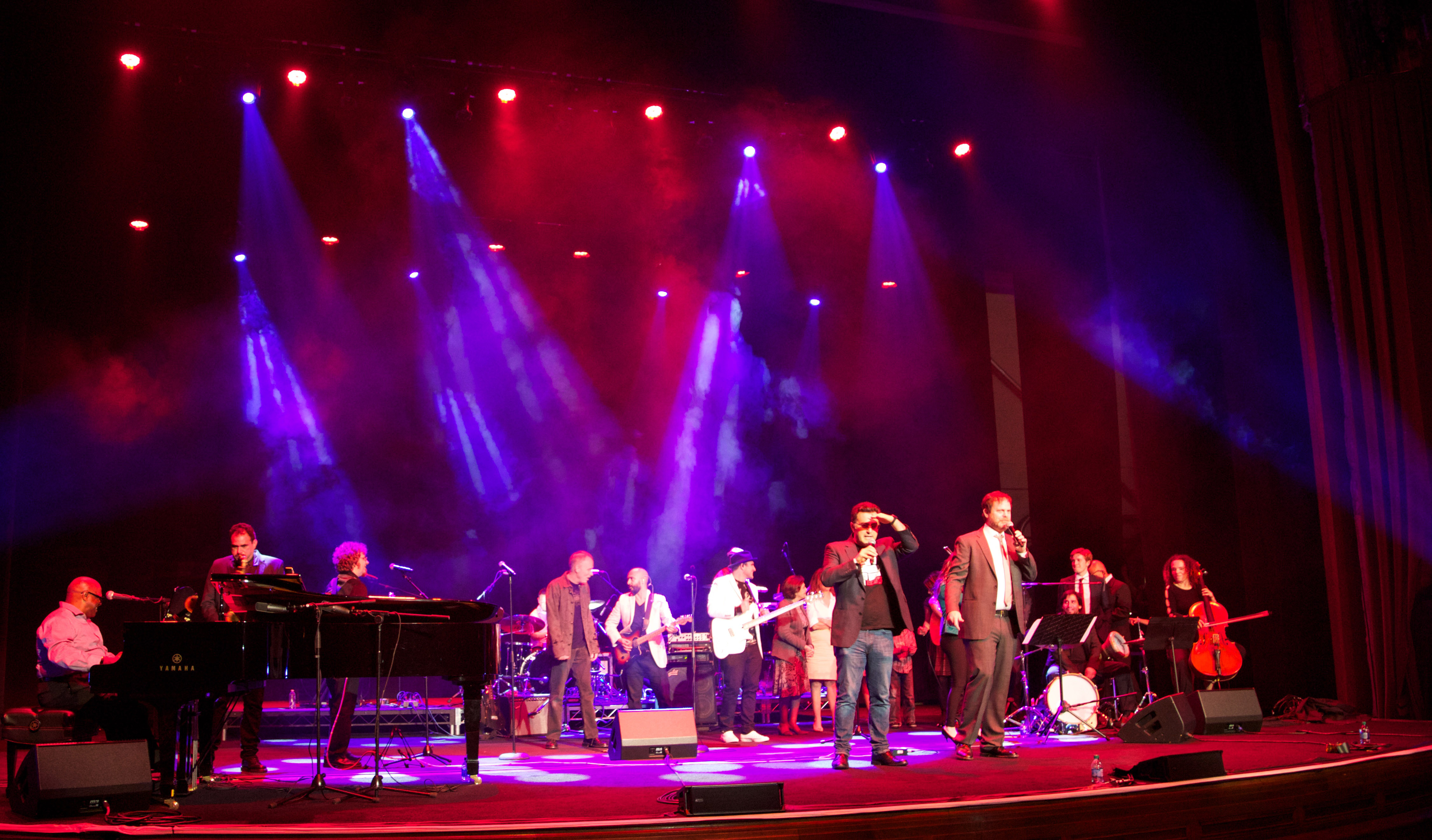 Musicians including Ellis Hall and members of the band Ozomatli perform at the Education is Not a Crime – Live 2015 event in Los Angeles on 27 February 2015. Maziar Bahari and Rainn Wilson are seen in the foreground.