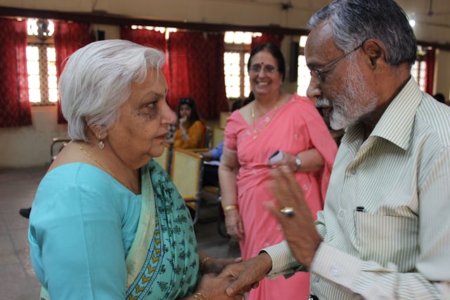 Dr. Janak Palta McGilligan (left) converses with a member of the audience with Dr. Shirin Mahalati in the background.