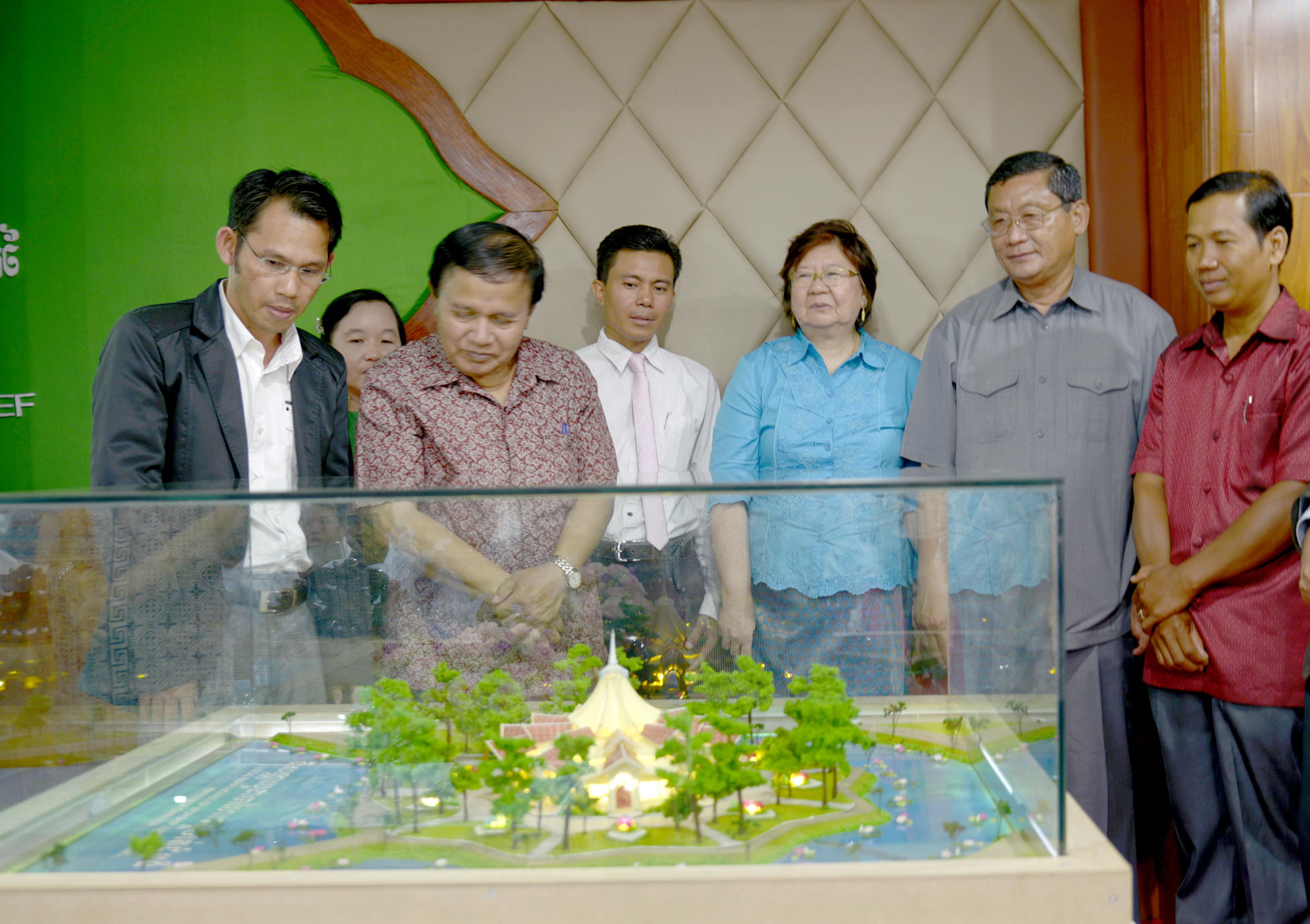 The architect explains his design to the Chairman of the Provincial Council as Governor Sophal looks on