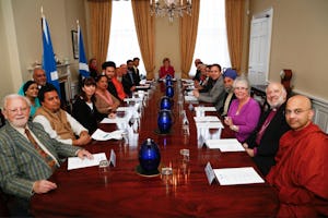 First Minister of Scotland Nicola Sturgeon sits at the head of a table at which gathered representatives of the country's religious groups, 8 September 2015 in Edinburgh. Baha'i representative Jeremy Fox is seated front left.