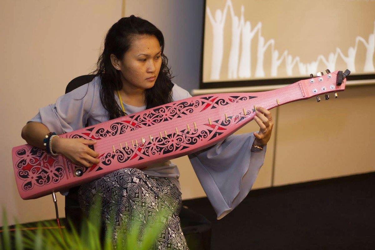A participant performs on a traditional string instrument from the Malaysian region of Sarawak. (photo: Baha'i community of Malaysia)