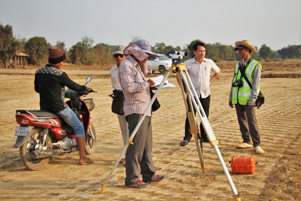 A team investigates the road levels at the site designated for the Baha'i House of Worship in Battambang, Cambodia.
