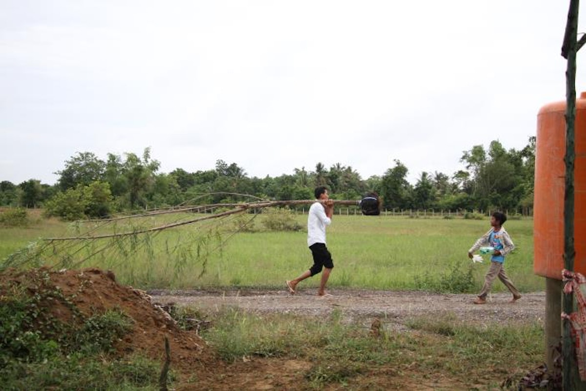 A young volunteer carries a tree to be planted on the Temple site.
