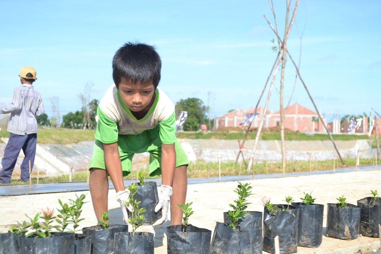 Children, youth, and adults in Battambang gathered at the site of the House of Worship to plant various trees and shrubs.
