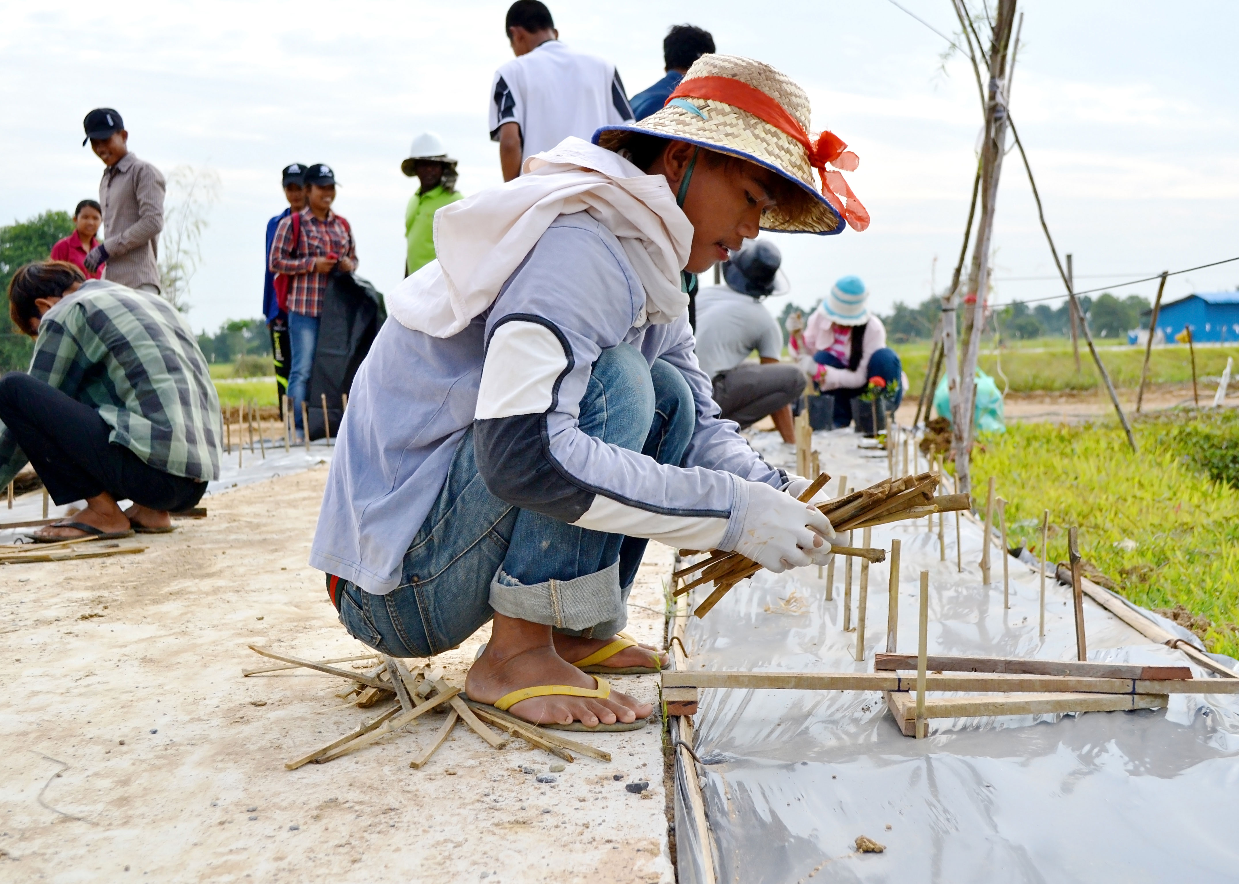 A volunteer prepares the soil for planting shrubs.