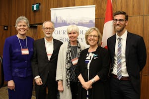 Los representantes de la comunidad bahá'í Gerald Filson (segundo desde la izquierda) y Geoffrey Cameron (derecha) están de pie junto a los miembros del comité directivo de Toda nuestra sociedad: Religión y Ciudadanía en el 150º de Canadá, entre ellos Elizabeth May (segunda desde la derecha), líder del Partido Verde.