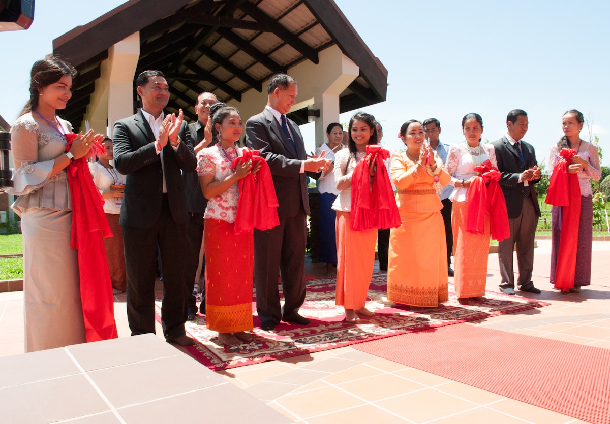 At the ribbon-cutting ceremony at the dedication of the local Baha’i House of Worship for Battambang: Deputy Governor of Battambang Chiem Chan Sophoan (front row, second from left), Deputy Secretary of the Ministry of Religion Sarey Chun (front row, fourth from left), representative of the Universal House of Justice, Sokuntheary Reth (front row, fourth from right), and Chairperson of the National Spiritual Assembly of the Baha’is of Cambodia, Chhit Samnang (front row, second from right)