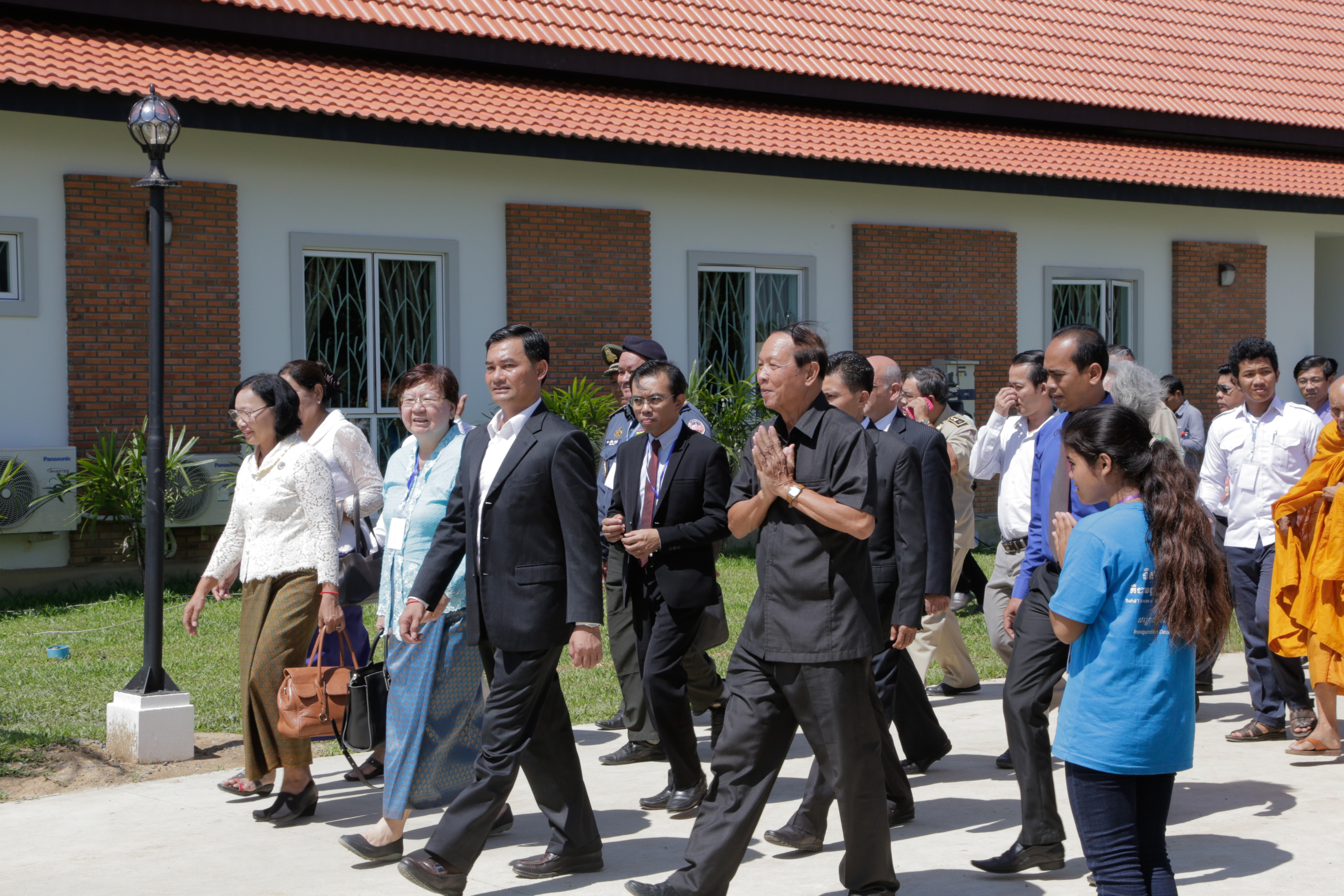 Dignitaries, officials, and representatives of the Baha'i community walk through the Temple grounds.