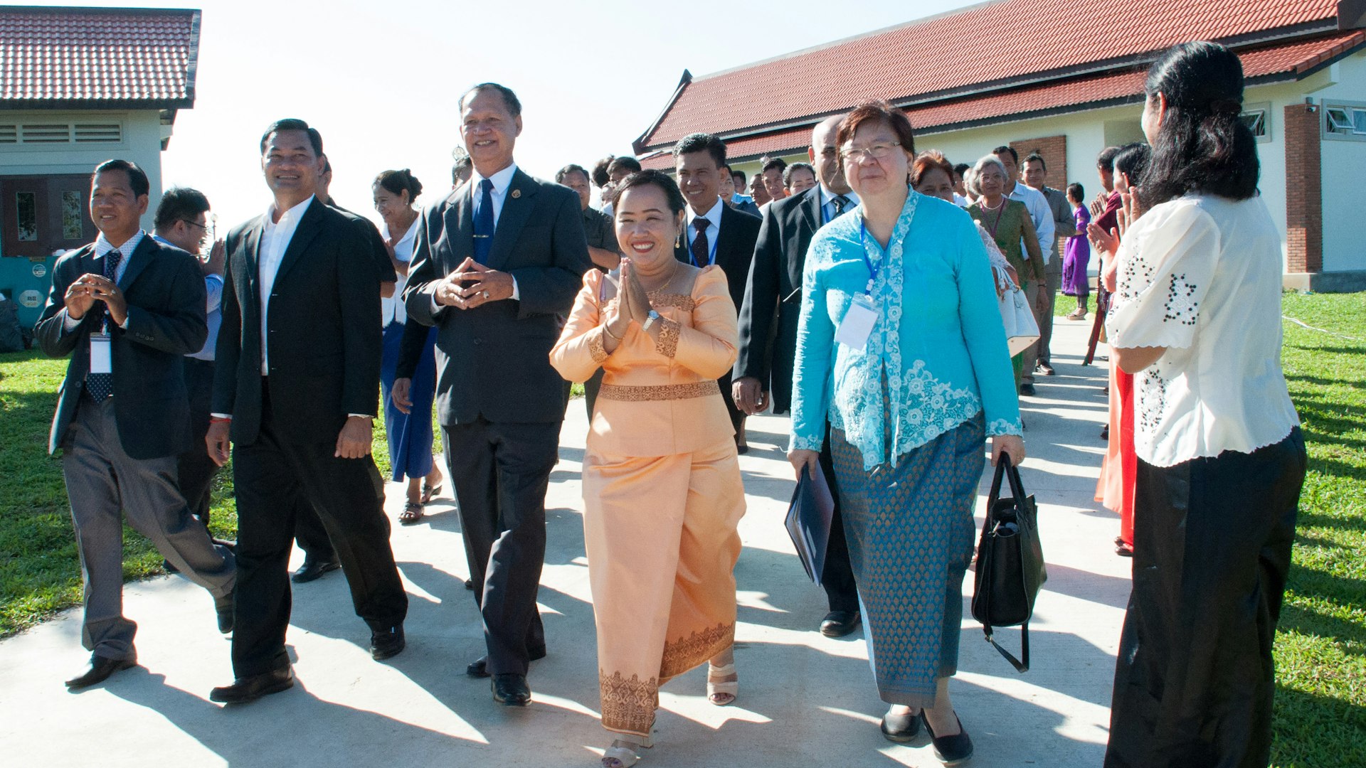 Representative of the Universal House of Justice, Ms. Sokuntheary Reth (center), walks with government representatives and representatives of the Baha'i community. Representative of the Universal House of Justice, Ms. Sokuntheary Reth (center), walks with government representatives and representatives of the Baha'i community.