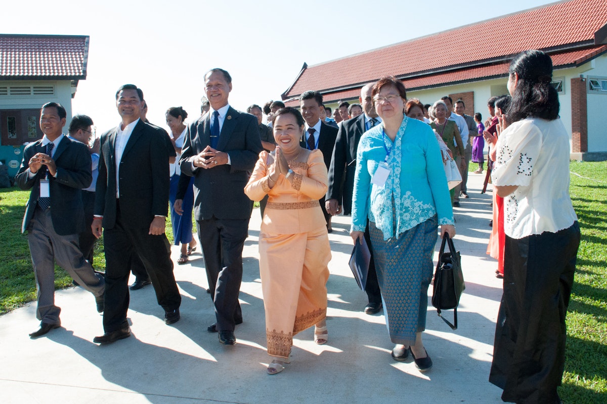 Representative of the Universal House of Justice, Ms. Sokuntheary Reth (center), walks with government representatives and representatives of the Baha'i community. Representative of the Universal House of Justice, Ms. Sokuntheary Reth (center), walks with government representatives and representatives of the Baha'i community.