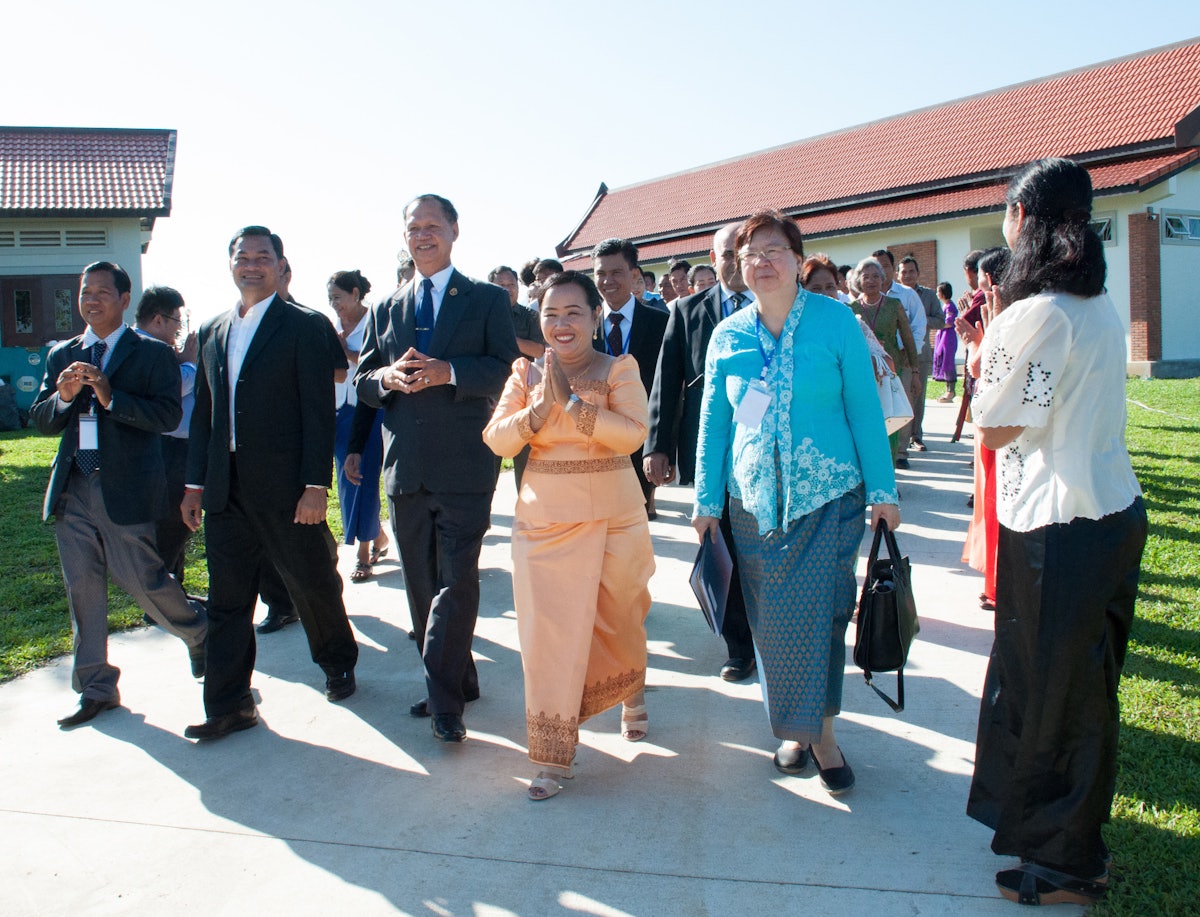 Representative of the Universal House of Justice, Ms. Sokuntheary Reth (center), walks with government representatives and representatives of the Baha'i community.