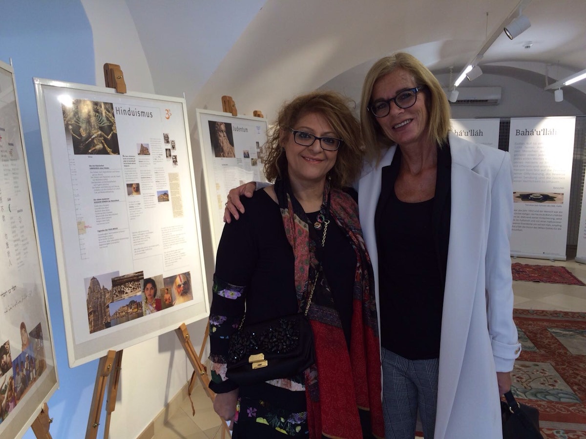 Sussan Zarifzadeh (left) and representative from the Catholic Church Eva Gorgosilich (right) in front of an exhibit prepared for last week's bicentenary celebrations in Bruck, Austria. The exhibition features the teachings of Baha'u'llah as well as the teachings of the other major religions of the world and highlights the imperative of unity.