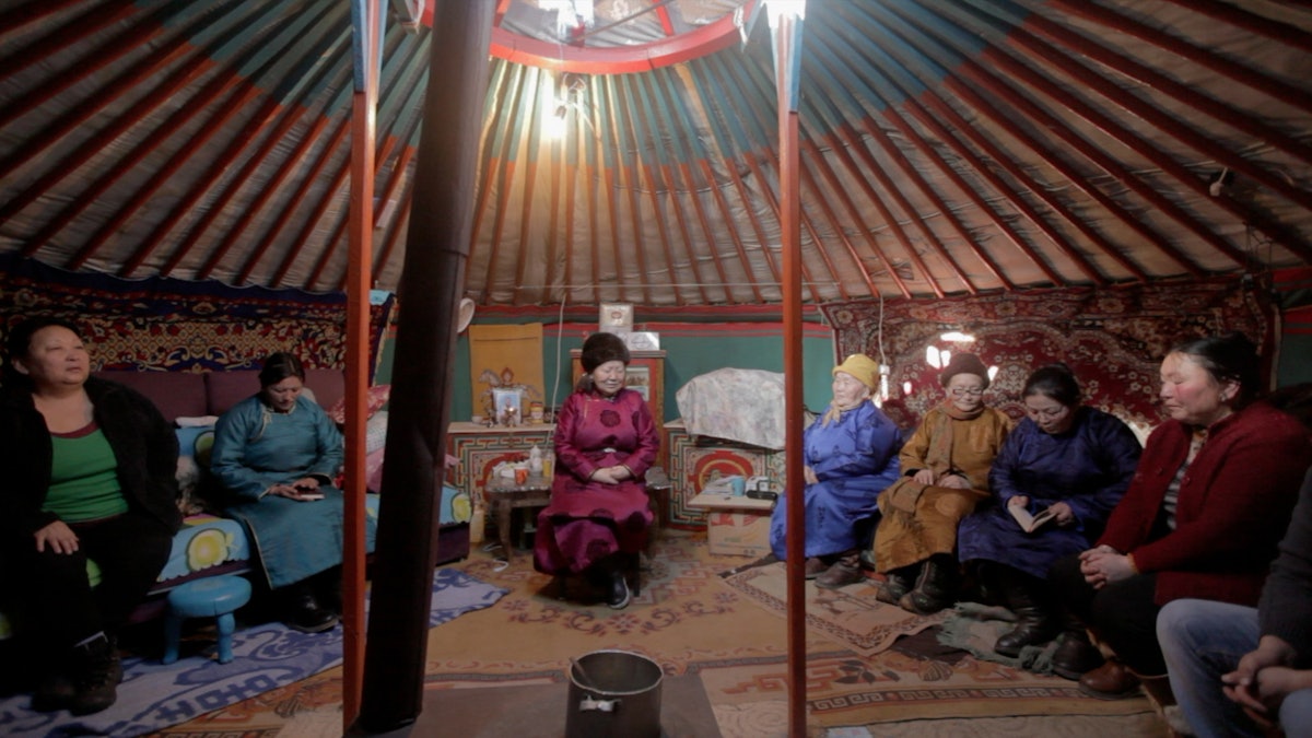 A group in Mongolia gathers in a yurt for prayers.