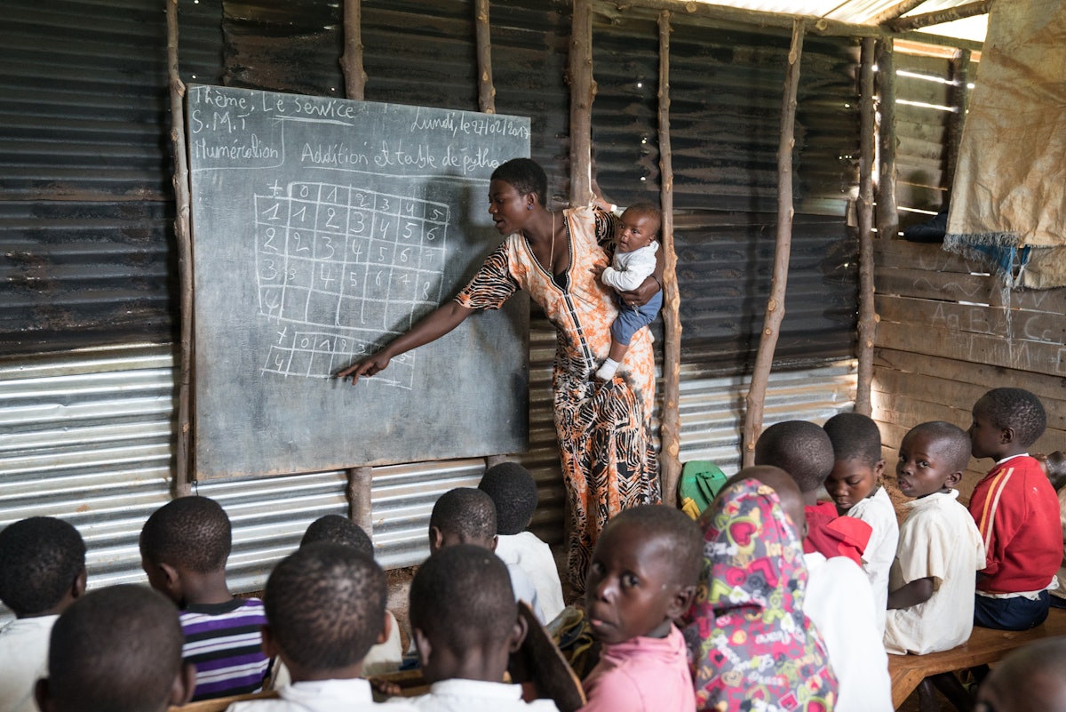 یک معلم در حال تدریس در مدرسۀ محلی در والونگو، جمهوری دموکراتیک کنگو