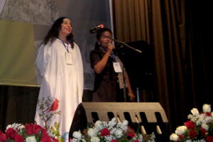 In a gown typical of her native Guajira region, one of the Colombian participants stands onstage at the conference in Quito to share experiences. A bus carrying 14 Baha’is from the Guajira crashed on the first leg of their long trip, yet only one of them had to return home.