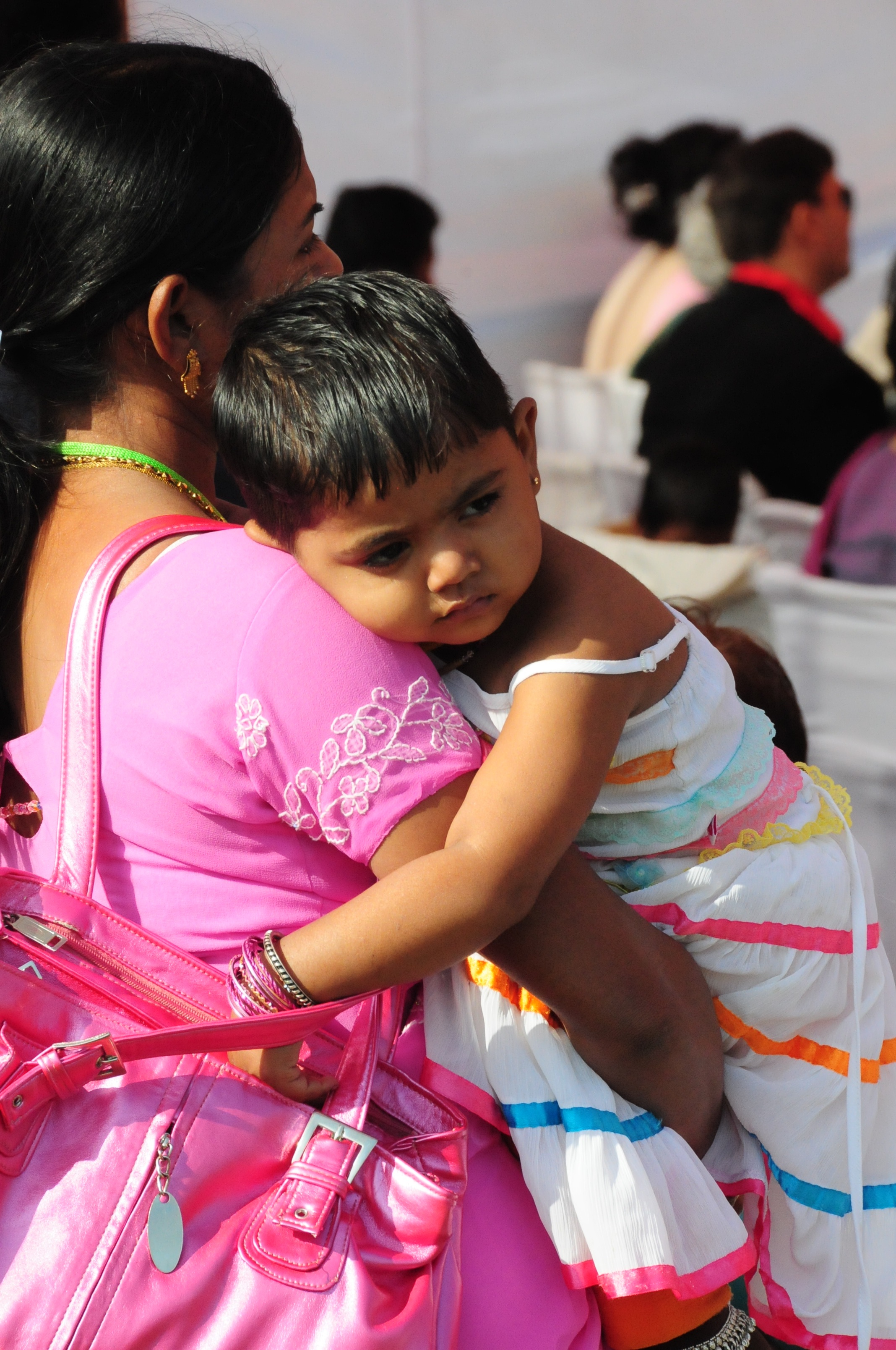 In New Delhi, a mother holds her sleepy daughter during conference proceedings. The New Delhi gathering, with 2,800 participants, was the largest of the first 10 regional gatherings.