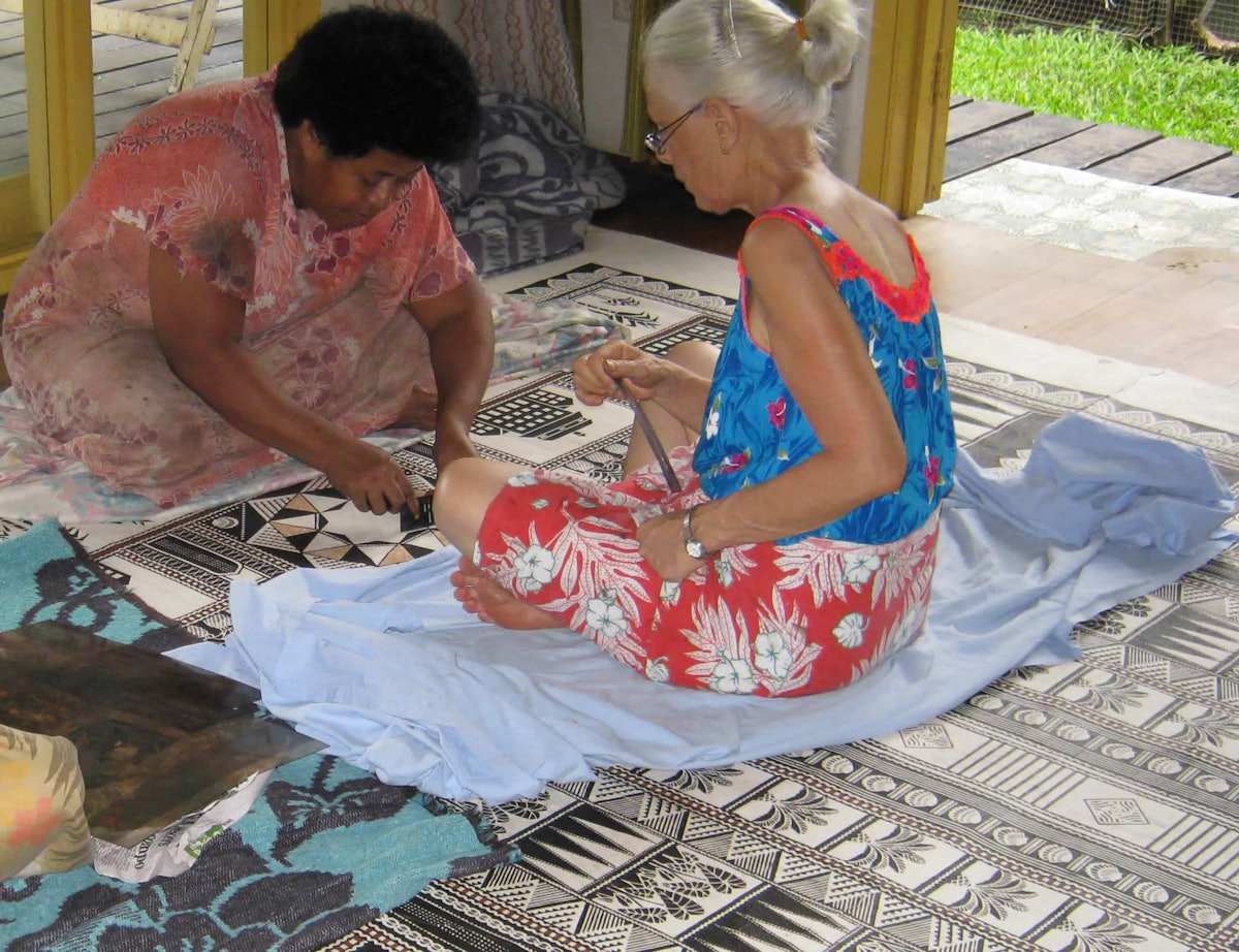 بالی جیون و رابین وایت، هنرمندان تاپاساز روی نقش پیچیده ای که برای پارچۀ با الیاف درختی در نظر دارند، کار می کنند. هنرمند سوم، لبا توکی، بیرون کادر دوربین قرار دارد. (همۀ عکس ها اهدایی از رابین وایت)