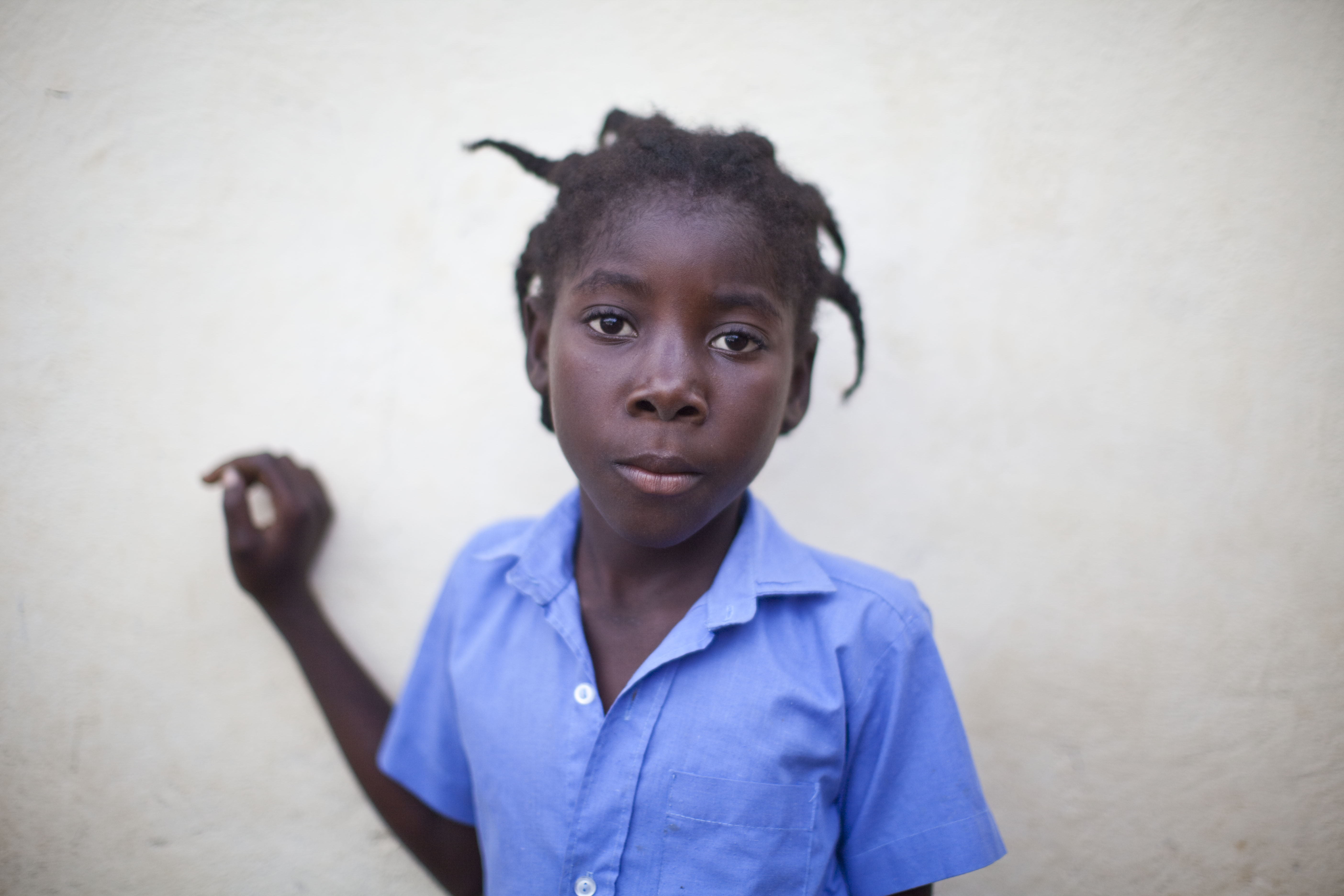 A young girl is captured by the camera at a makeshift clinic next to a collapsed school in a village near Port-au-Prince.
