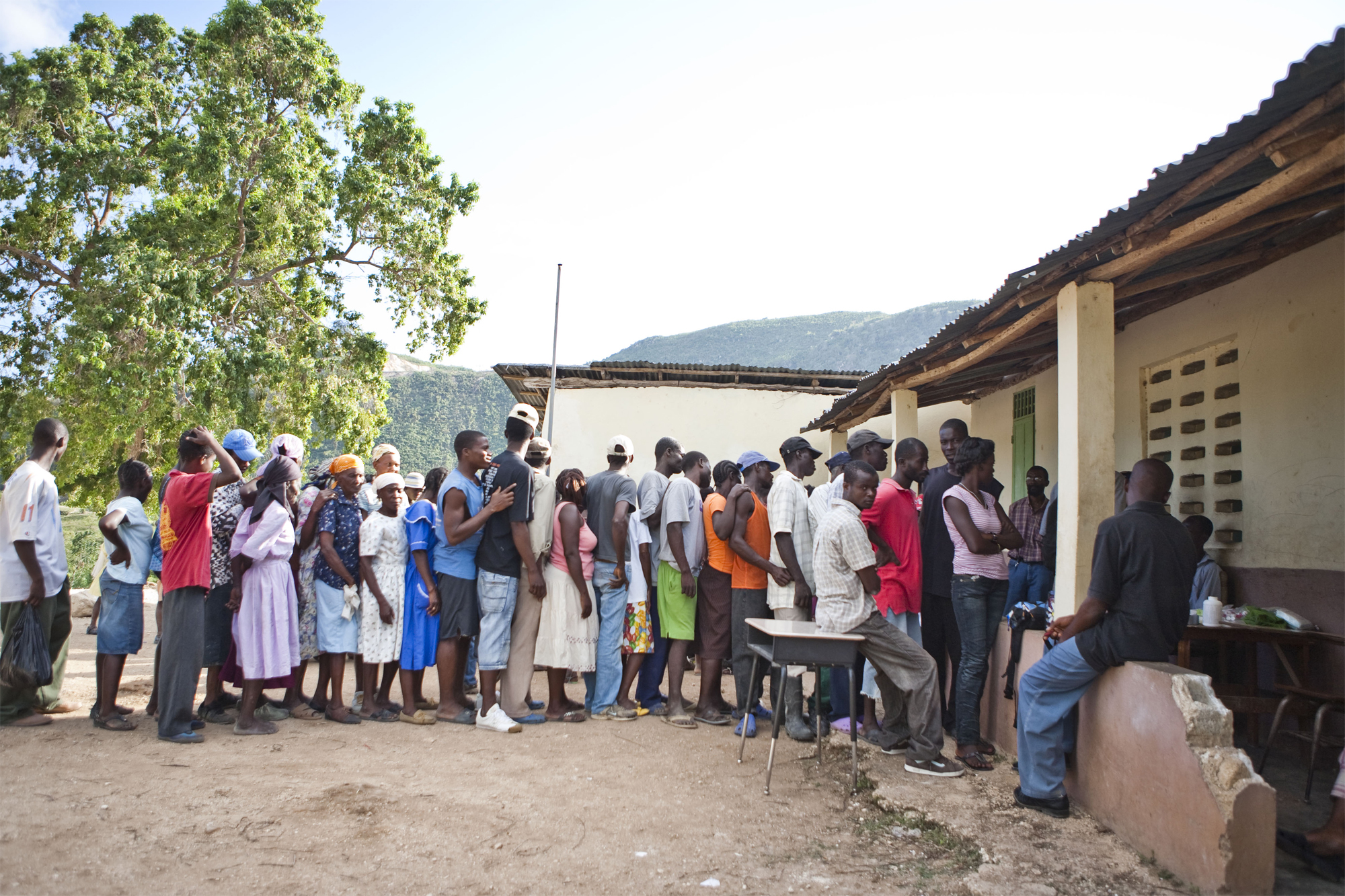 The visiting doctors saw hundreds of patients. These people are waiting in line at a clinic in a village near Port-au-Prince.