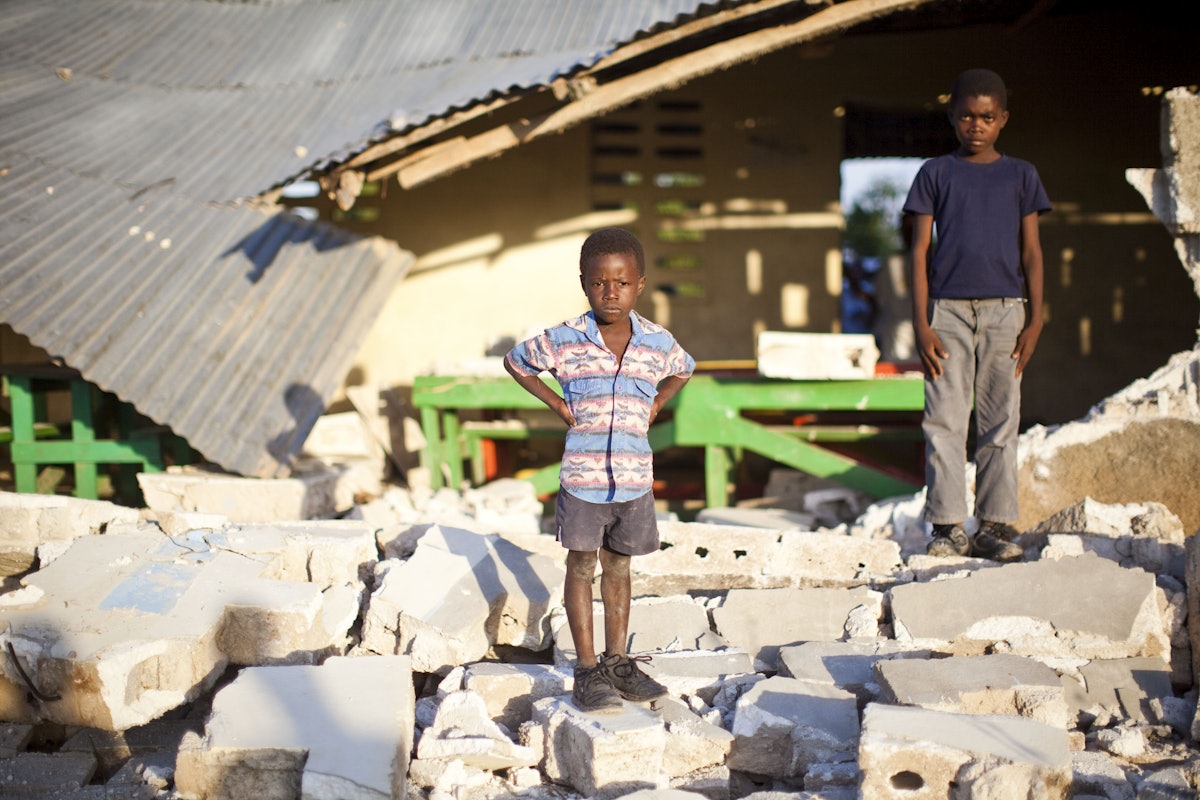 Local children stand in the ruins of a school in a village outside Port-au-Prince. A large number of the buildings in the Haitian capital were damaged or destroyed.
