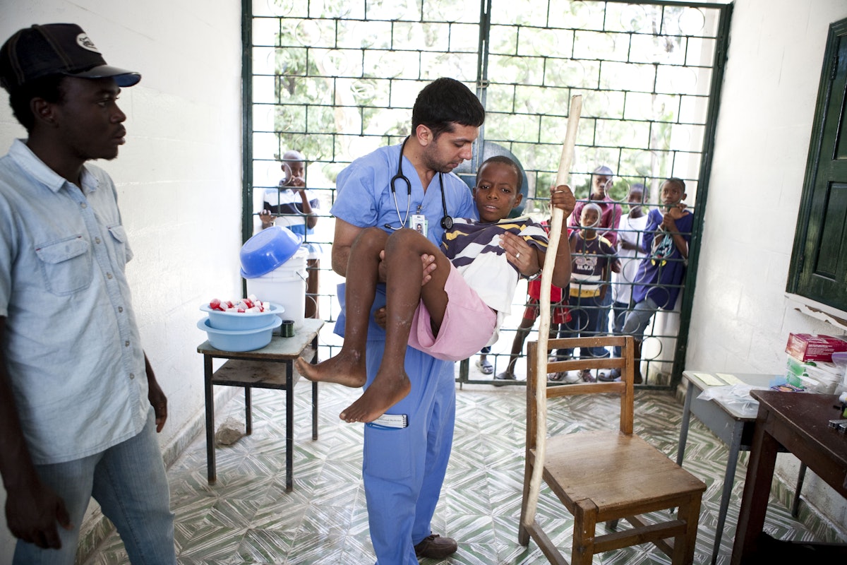Knowing that no supplies would be available in Port-au-Prince and that the infrastructure of the country had collapsed, members of the medical team brought with them everything they needed for their makeshift clinics. Here Dr. Poya Azar is shown with an injured youth.