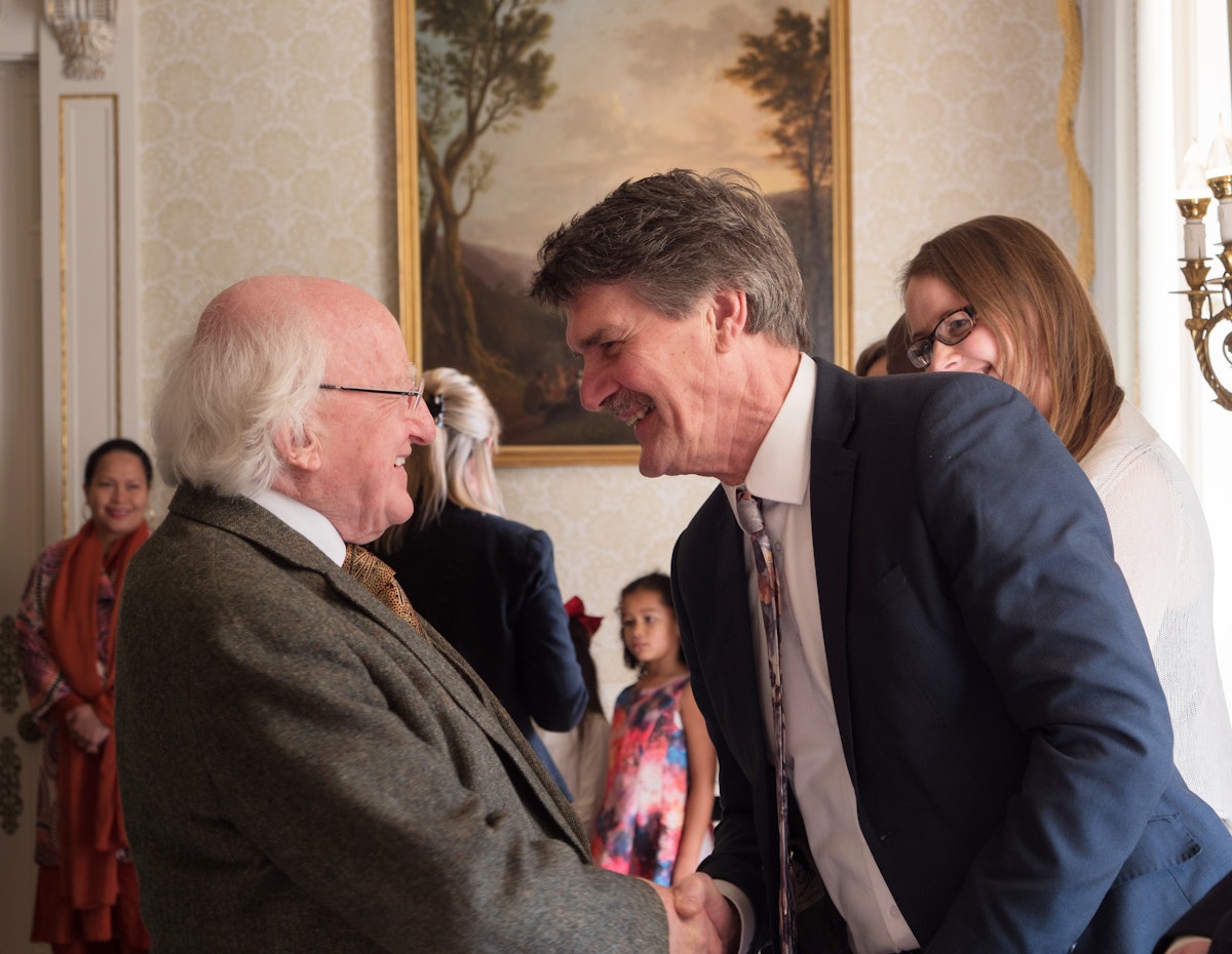 Le président irlandais Michael Higgins saluant les membres de la communauté bahá’íe lors de la réception du bicentenaire.