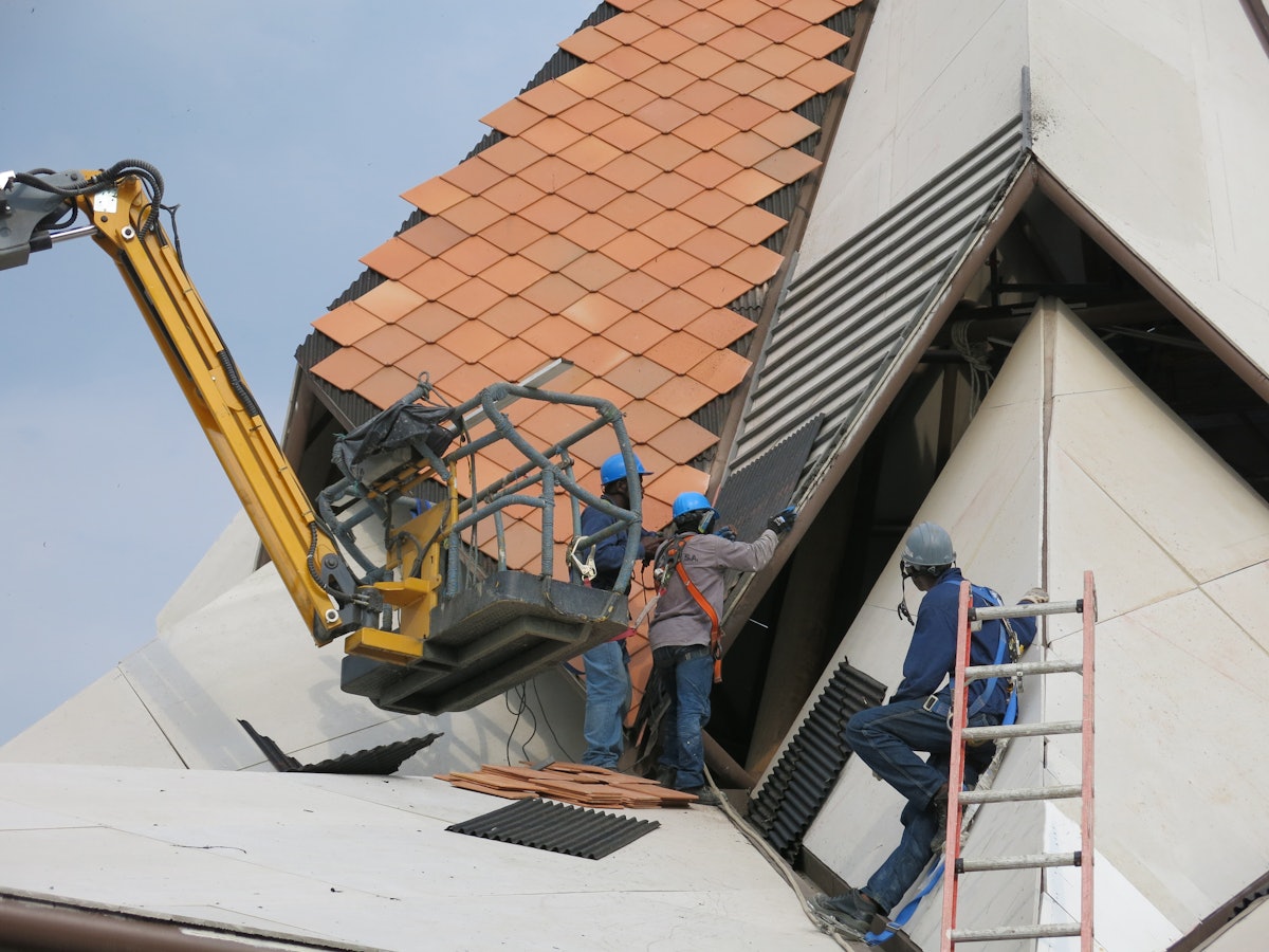 Workers laying tiles on the roof of the House of Worship in Norte del Cauca, Colombia