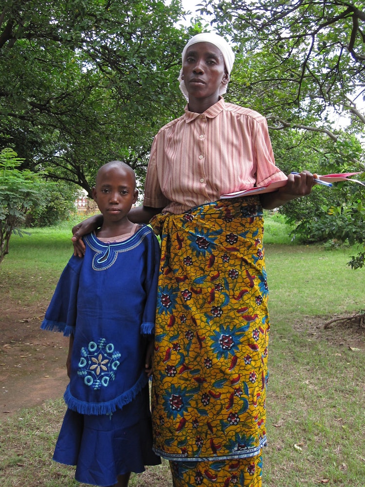 Christine Ndayikengurutse, right, a member of the Batwa people, who attended the national Baha'i convention in Burundi as one of 19 elected delegates. Mrs. Ndayikengurutse, who is illiterate, was accompanied by a young girl, pictured left, who is able to go to school and assisted her to fill out her ballot.