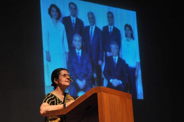 Farah Motallebi – a niece of Iranian Baha'i prisoner Fariba Kamalabadi – addresses an audience of some 250 people at a Solidarity Concert held at the Baha'i House of Worship in New Delhi, India, 18 May 2011, to mark the third anniversary of the arrest of the seven Baha'i leaders, pictured behind her. Mrs. Motallebi called for Iran to uphold human rights and justice for all its citizens, irrespective of their affiliation to any belief, religion or ideology.