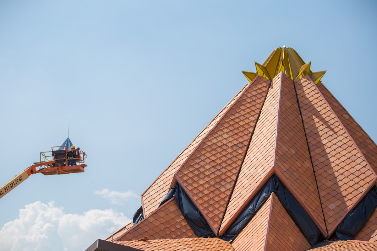 The crown at the top of the roof of the Colombia Temple being put into place.