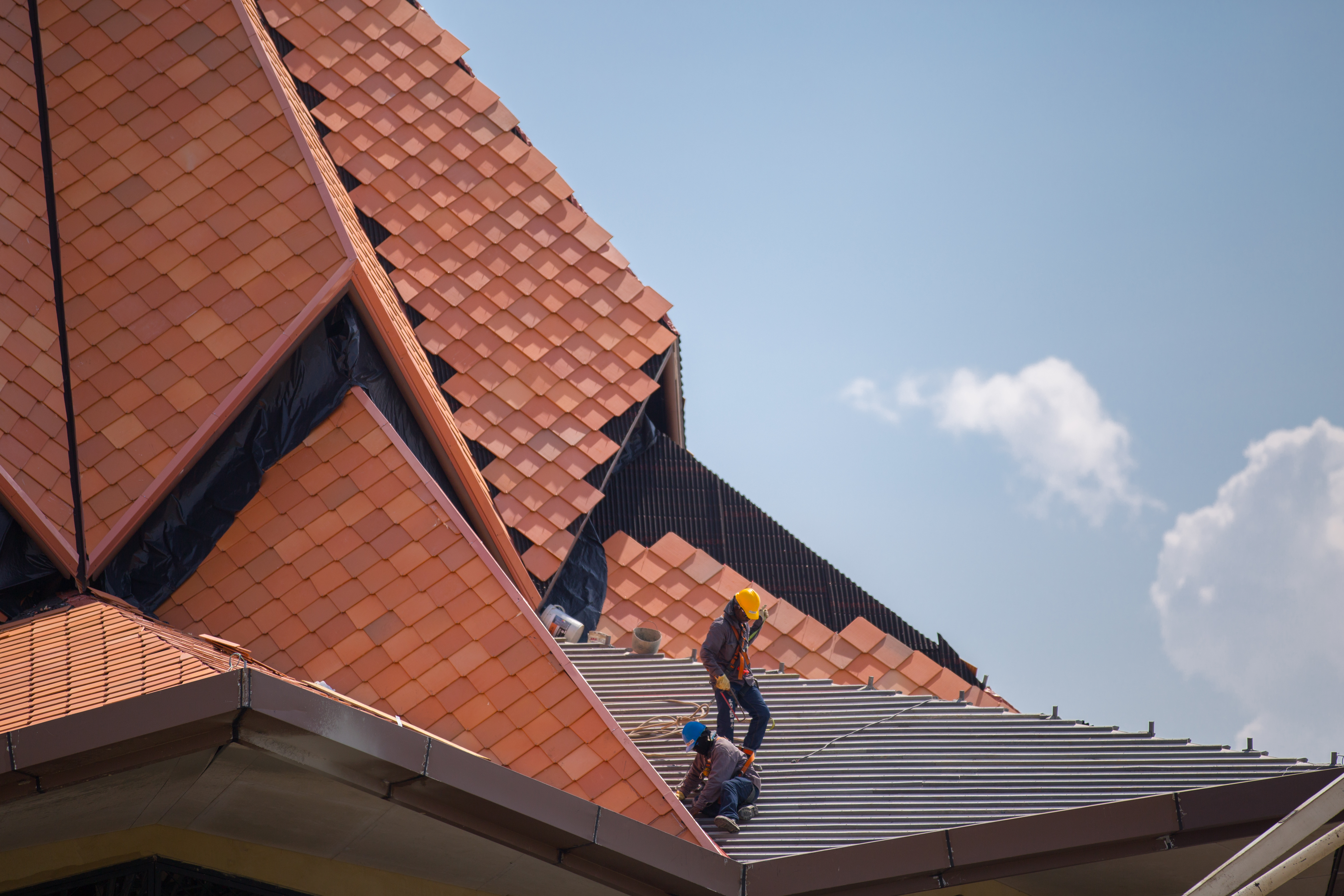 Workers lay terracotta tiles on the Temple’s roof