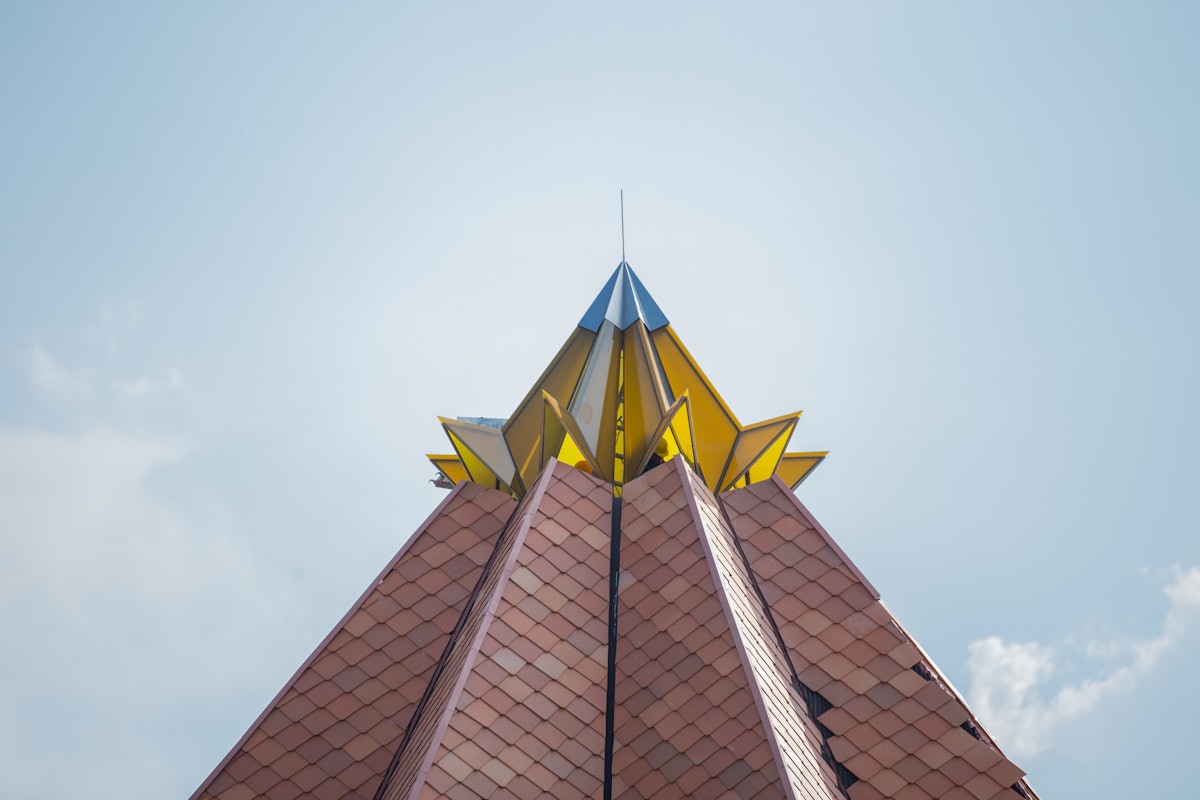The yellow structure that sits atop the terracotta-tiled roof represents the blooming cocoa flower—an iconic symbol in the country.
