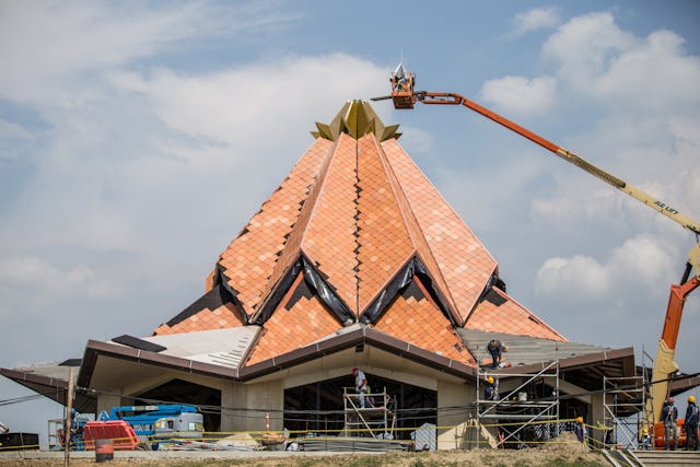 Workers put the crown at the top of the roof of the local House of Worship in Norte del Cauca, Colombia.