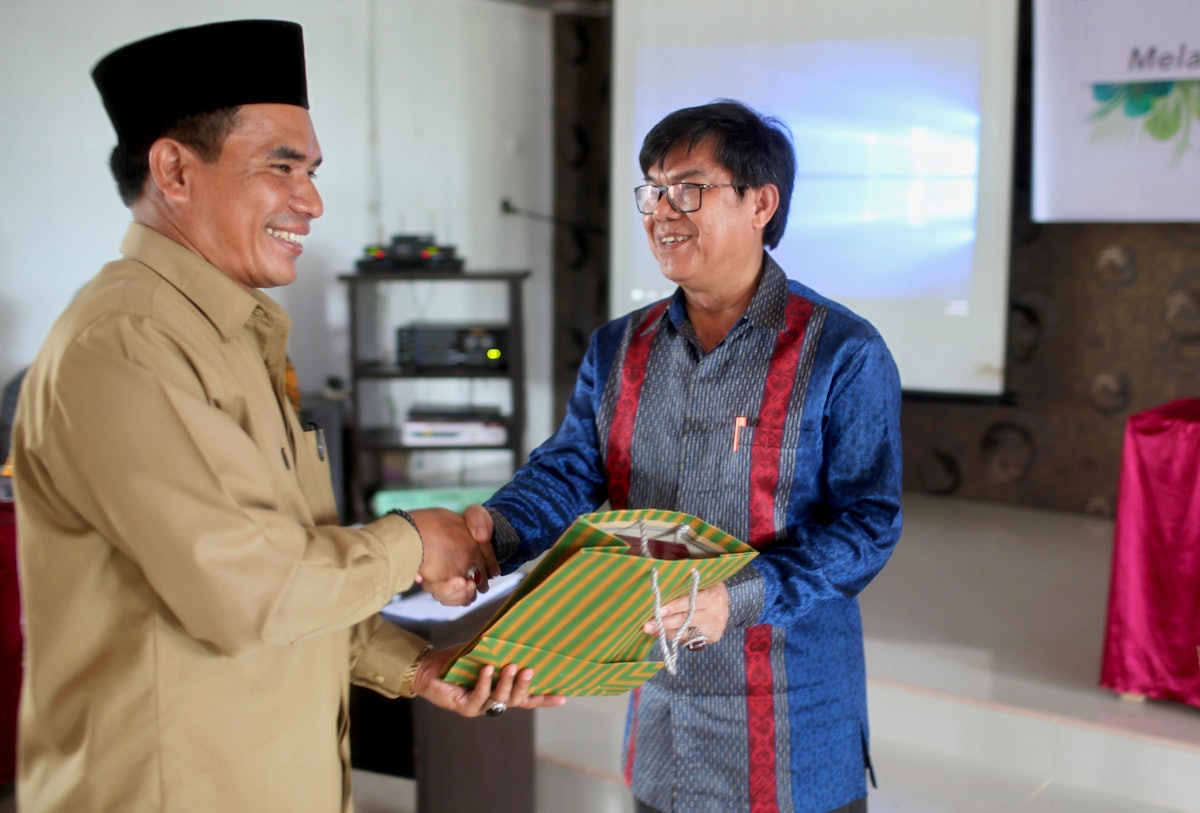 Mr. Haji Ibnu Hasan Muchtar, Senior Researcher from Indonesia’s Ministry of Religion, receives a gift from the Baha’i community of Indonesia.