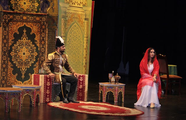 This scene depicts when Nasiri’d-Din Shah, the king of Persia, met with Tahirih, offering to marry her if she recanted her faith. Tahirih turned down the offer with poetry: “Kingdom, wealth, and power for thee / Beggary, exile, and loss for me / If the former be good, it’s thine / If the latter is hard, it’s mine.”