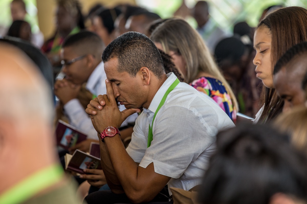 Participants à un programme de dévotion écoutant les prières à l’intérieur du temple, dimanche.