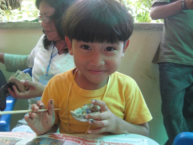At the Baha’i summer school in Venezuela, young Key Aray joins in during a creative art project. Arts and music were part of the program each day for all age groups.