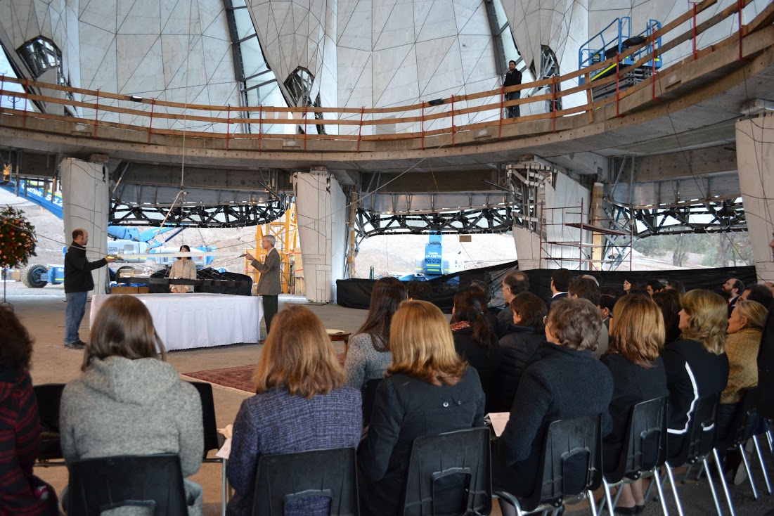 Those present for the placement of the symbol of the Greatest Name look on as it is raised towards the dome of the temple.