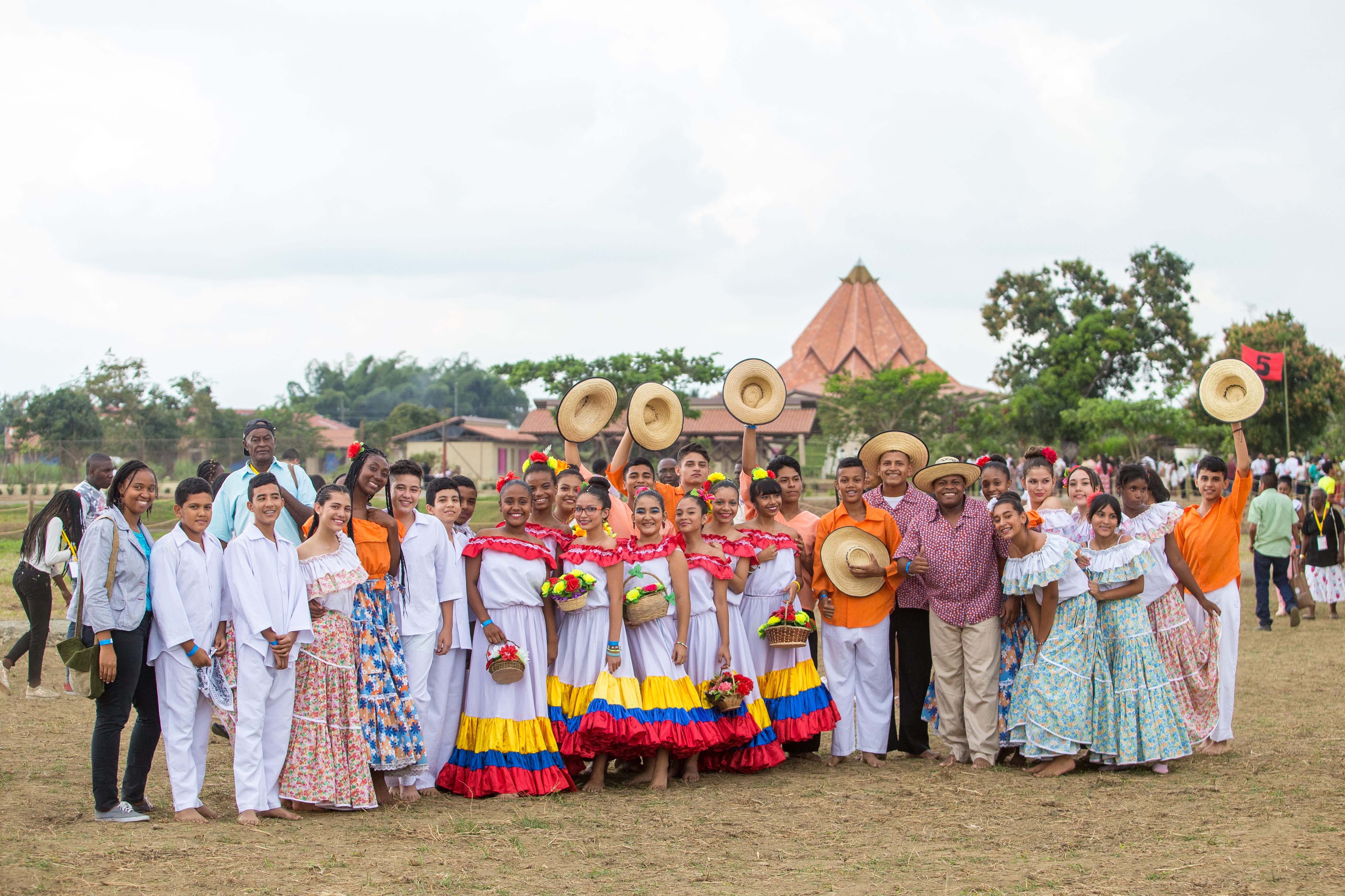 Some of Sunday’s performers, who are students from a nearby Baha’i-inspired school, smile and wave during the gathering.