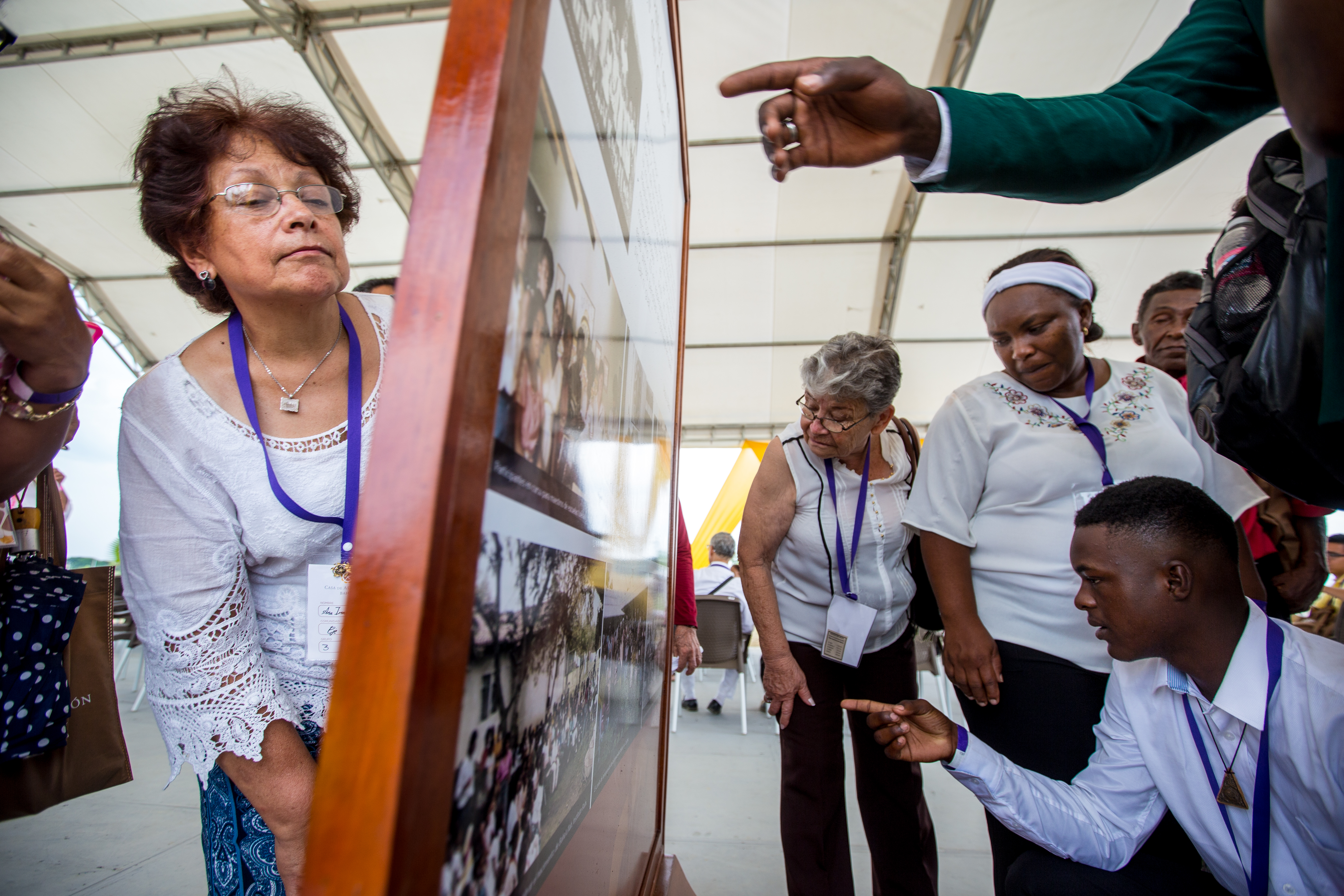 Participants in the dedication ceremony look closely at displays showing the history of the Baha’i Faith in the Norte del Cauca region of Colombia.
