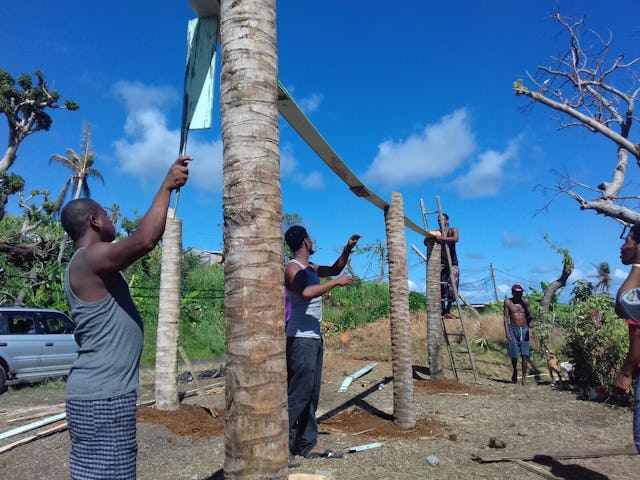 In the months following September 2017, when Hurricane Maria devastated the Caribbean island of Dominica, the community united in reconstruction efforts. Here, youth and adults work together to build a greenhouse in the island’s Kalinago territory.