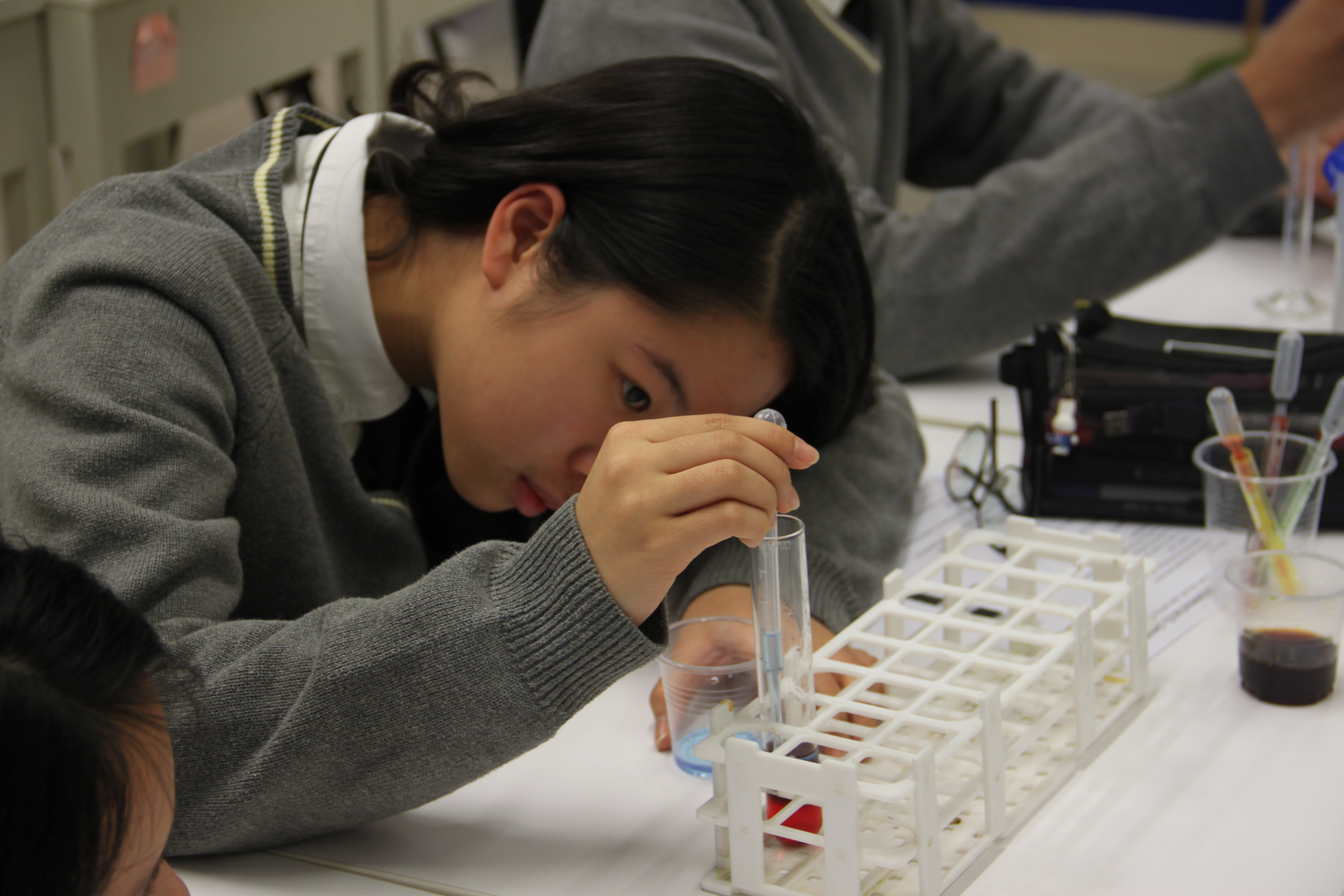 A high school student conducts a science experiment.