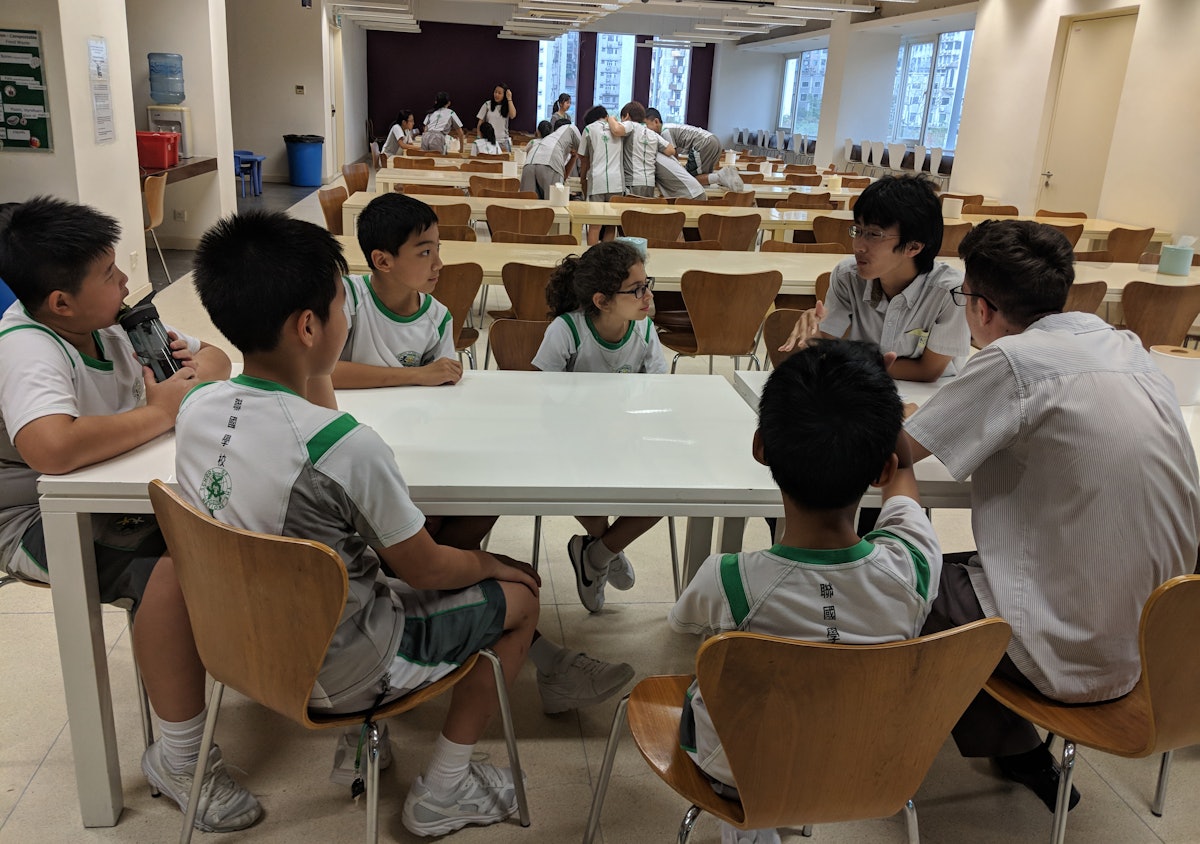 Deux lycéens aidant un groupe de collégiens dans le cadre du programme d’habilitation morale de l’école.